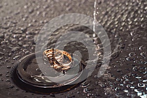 Wedding rings on a chrome plated surface. water drops with reflections of light. water splashes