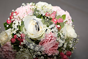 Wedding rings close up on bouquet flowers marriage