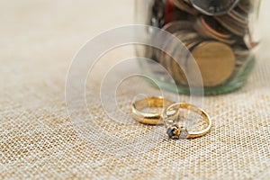Wedding rings with Coins in jar, saving money for marry