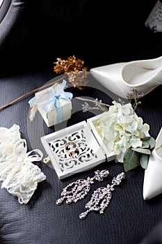 Wedding rings in a decorative box with flowers, earrings, women`s shoes, a garter of the bride, a small gift
