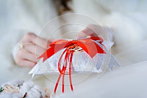 Wedding rings on decorative white pillow