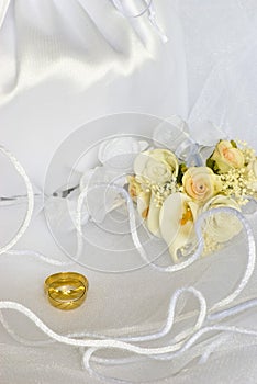 Wedding rings flowers and bridal bag over veil