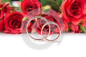 The wedding rings and flowers isolated on white background