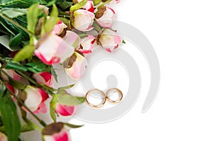 The wedding rings and flowers isolated on white background