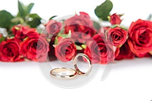 The wedding rings and flowers isolated on white background