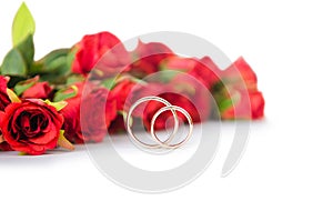 The wedding rings and flowers isolated on white background