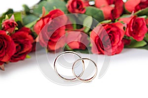 The wedding rings and flowers isolated on white background