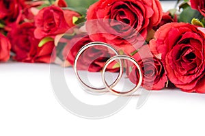 The wedding rings and flowers isolated on white background