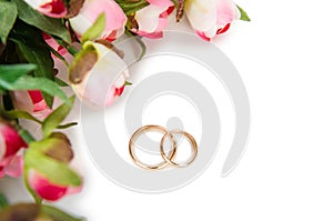 The wedding rings and flowers isolated on white background