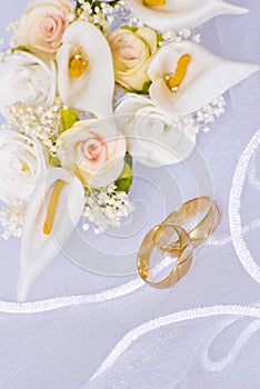 Wedding rings and flowers over veil