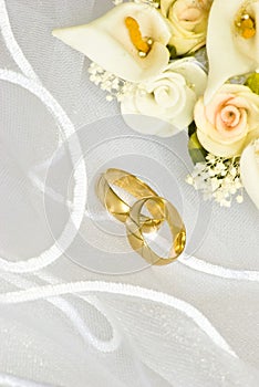 Wedding rings and flowers over veil