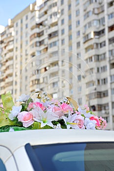 Wedding rings and flowers on roof of car