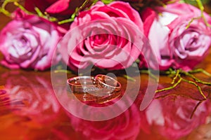 WEDDING, Rings and flowers: Wedding rings and Bridal bouquet of red roses.