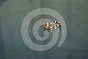 Wedding rings on a glass table.