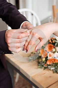 wedding rings and hands of bride and groom. young wedding couple at ceremony. matrimony. man and woman in love. two happy people c