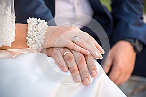Wedding rings on the hands of the groom and the bride