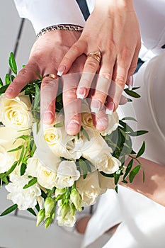 Wedding rings on hands with white flowers. bridal moments
