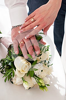 Wedding rings on hands with white flowers. bridal moments