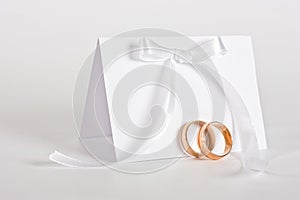 Wedding rings and invite with white bow