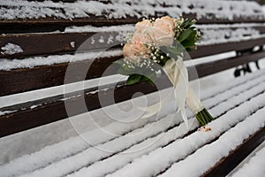 Wedding rings lie on snow covered bench in a Park on a frosty morning