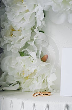 Wedding rings next to white flowers
