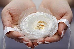 Wedding rings in the palms of the bride