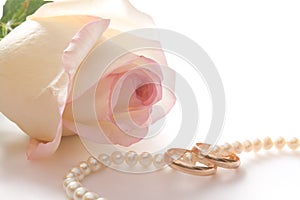 Wedding rings, pearl beads and rose, isolated