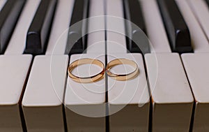 Wedding rings on the piano keys golden wedding rings lie on the piano free space for text