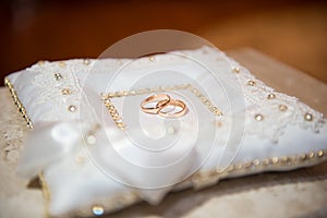 Wedding rings on the pillow.