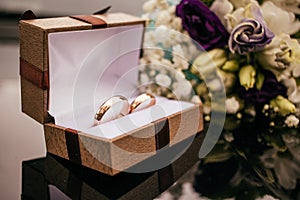 Wedding rings with  pink flowers on a  grey background