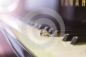 Wedding rings placed on piano keys.