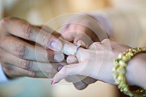 Wedding rings. He Put the Wedding Ring on Her. Close up Groom Put the Ring on bride.