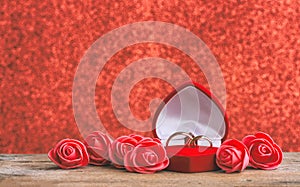 Wedding rings in red gift box heart shape, roses