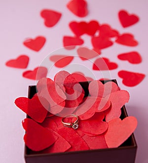 Wedding rings on the red hearts. Pink background. The concept of betrothal, divorce, parting, infidelity .Selective focus