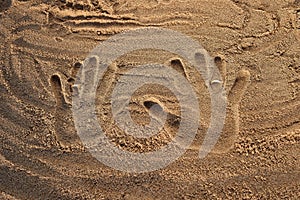 Wedding rings on the sand handprints