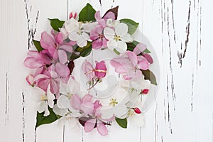 Wedding rings with spring apple tree blossoms on white old wooden background.