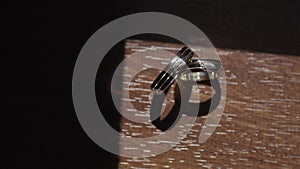 Wedding rings stand on a table that shine bright sunlight with interesting geometry. close-up