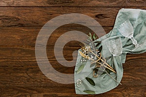 Wedding rings and table cutlery on rustic background.