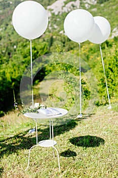 Wedding rings table and white balloons