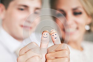 Wedding rings on their fingers painted with the bride and groom