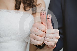 Wedding rings on their fingers painted with the bride and groom, funny little people