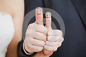 Wedding rings on their fingers painted with the bride and groom, funny little people