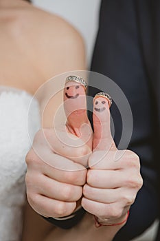 Wedding rings on their fingers painted with the bride and groom, funny little people