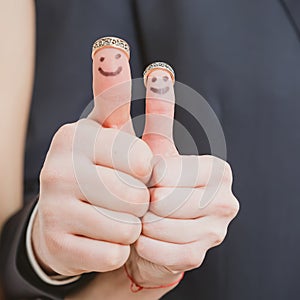 Wedding rings on their fingers painted with the bride and groom, funny little people