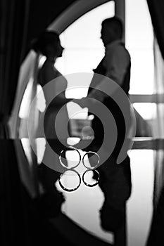 Wedding rings for the wedding and marriage of the bride and groom. Silhouette of the bride and groom black and white