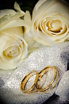 Wedding rings with white roses.