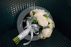 Wedding roses and peonies on a wicker chair. Wedding in Monteneg