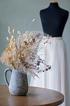 Wedding salon interior. Flowers in a vase and mannequin in white skirt