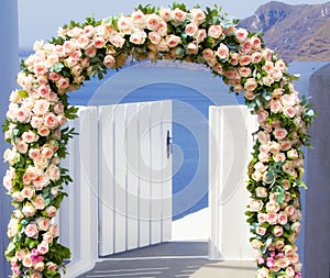 Wedding at Santorini. Beautiful arch decorated with flowers of roses with  blue church of Oia, Santorini, Greece at most romantic