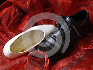 Wedding shoes snuggling on red silk